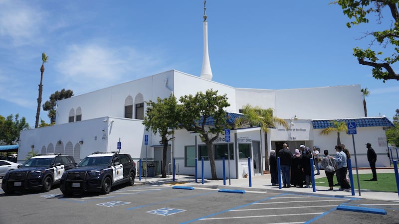 FILE - People gather as police vehicles are parked outside of the Islamic Center of San Diego,...