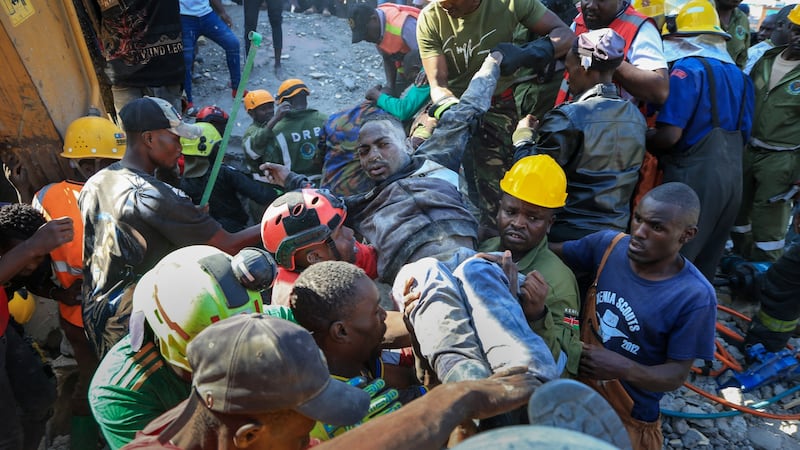 Los rescatistas trasladan a un hombre que resultó levemente herido en el derrumbe de un...