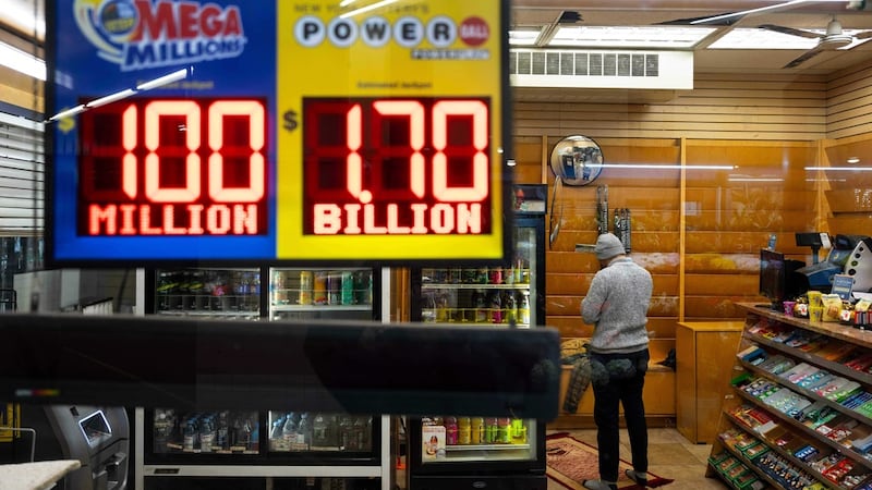 Una tienda de conveniencia muestra los premios grandes del Powerball y Mega Millions, el...
