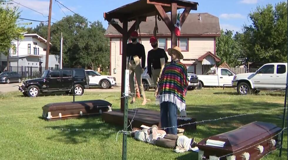 The Halloween display shows two figures with nooses around their necks. They are wearing red...