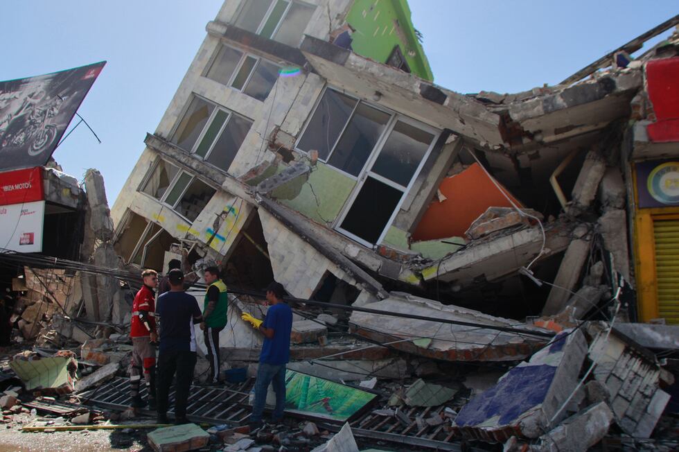 Residentes buscan entre los escombros de un edificio tras un terremoto, el lunes 10 de agosto...