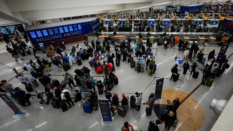 Travelers move through Hartsfield-Jackson Atlanta International Airport, Friday, Dec. 20,...