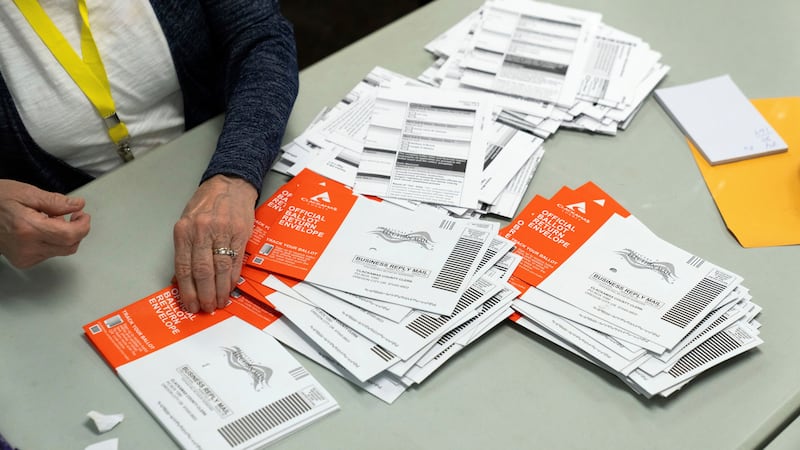 ARCHIVO - Un miembro del personal electoral toma una boleta sin abrir durante el proceso de...