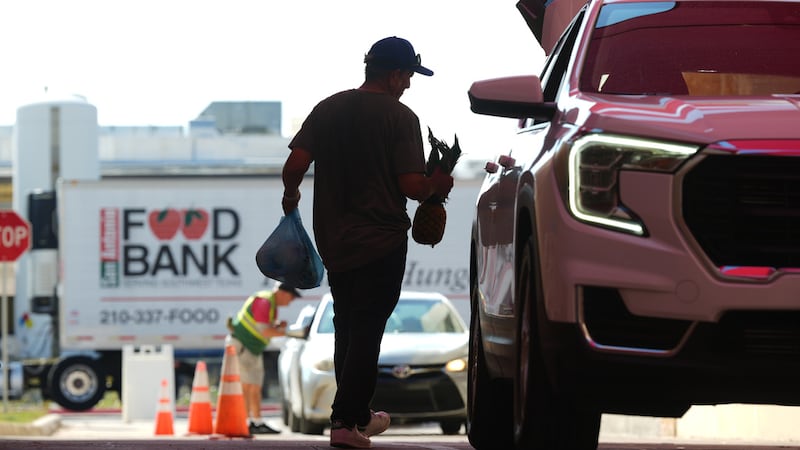 El voluntario Joel Hernandez ayuda a cargar un vehículo durante una actividad de distribución...